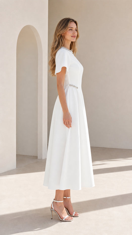 Side profile view of woman wearing white A-line midi formal dress