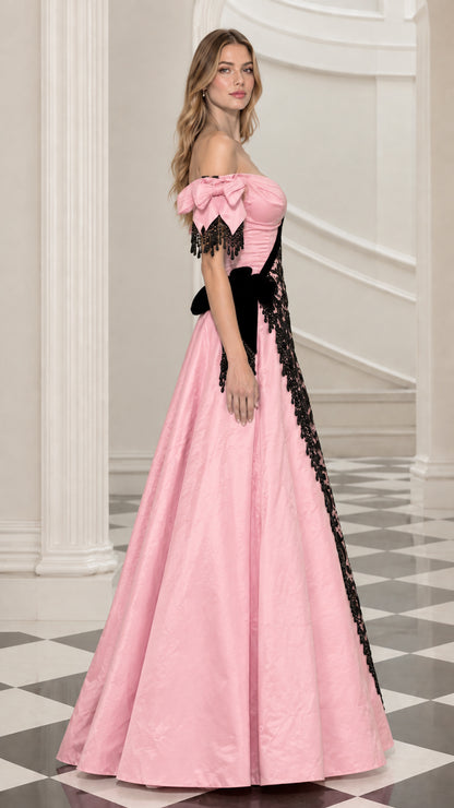 Side profile view of pink taffeta formal gown with asymmetric black lace overlay