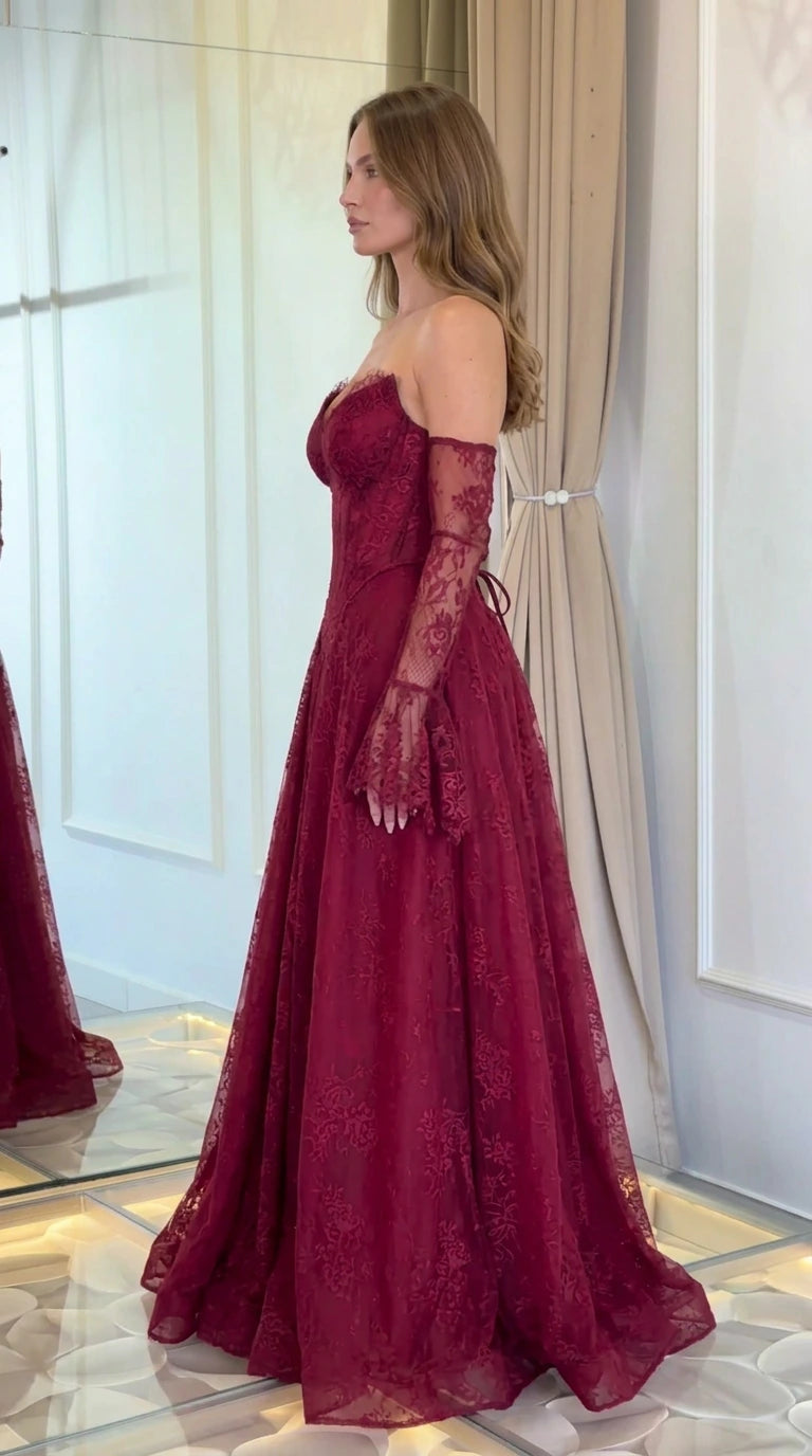 Side profile view of model in burgundy lace A-line formal gown