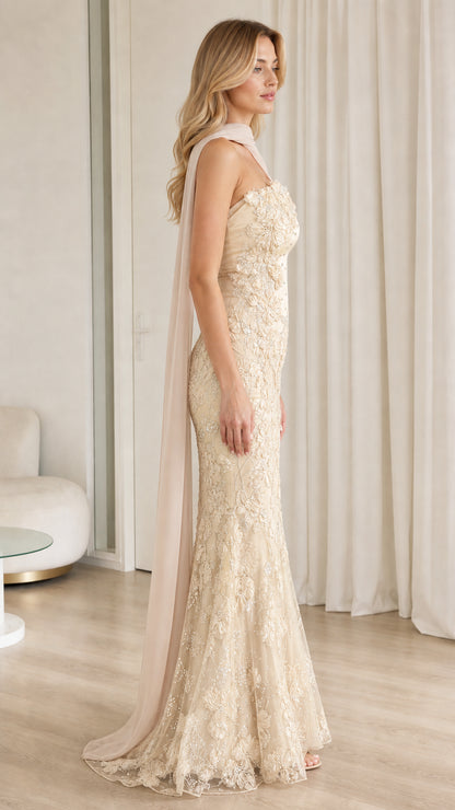Side profile view of champagne embroidered lace evening gown showcasing floor-length flare