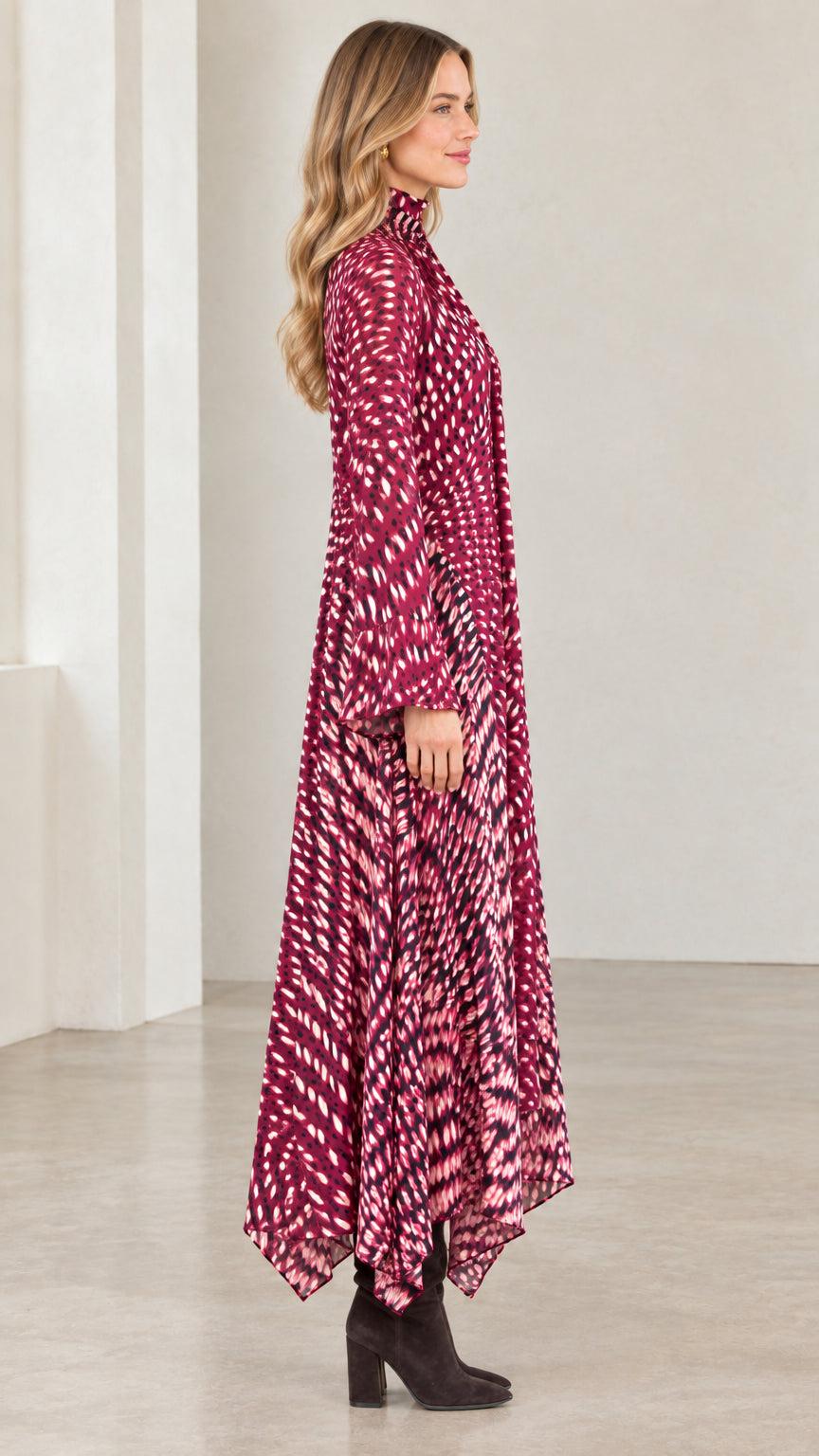 Side view of model showing the flowing silhouette of the magenta tie-neck dress