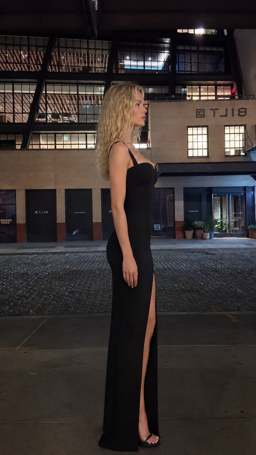 Side profile view of black corset maxi dress showing high thigh slit