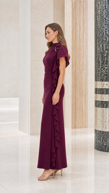 Side profile view of woman modeling the burgundy asymmetrical ruffle evening gown