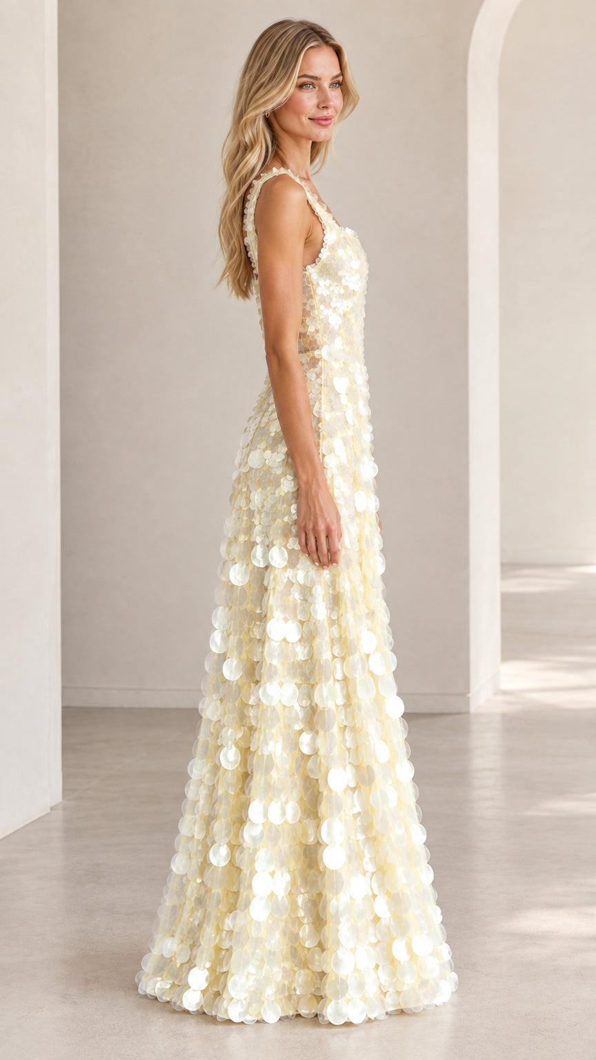 Side profile of model wearing ivory floor-length sequin evening dress