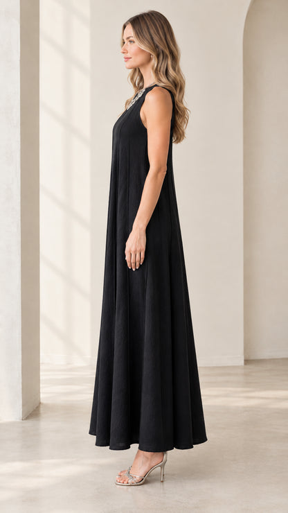 Side profile view of woman wearing black flowy sleeveless maxi dress