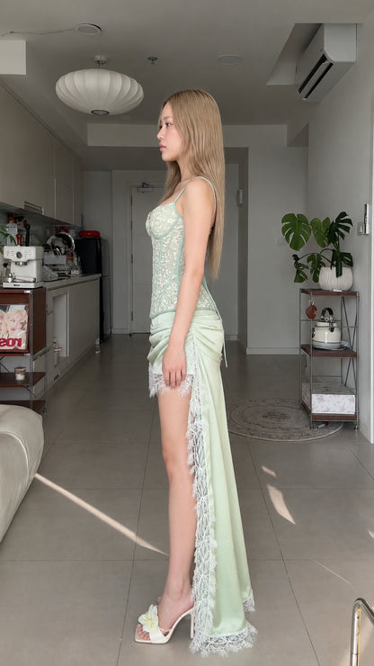 Side profile of sage green lace corset top and asymmetrical draped skirt