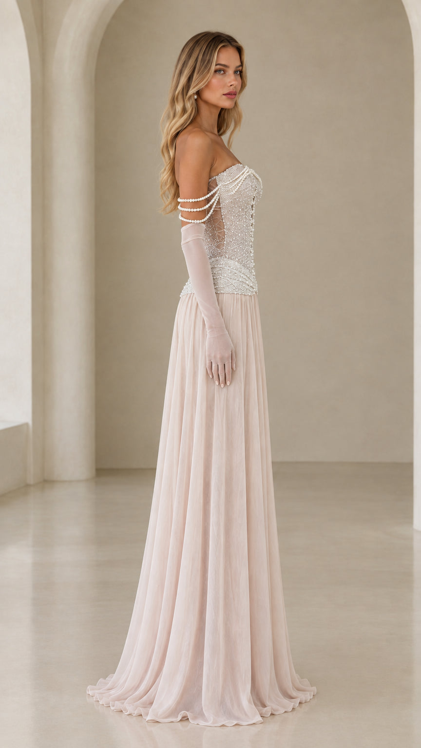 Side profile of model in champagne pearl embellished drop-waist maxi gown