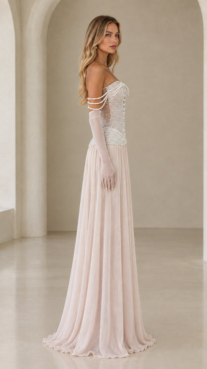 Side profile of model in champagne pearl embellished drop-waist maxi gown