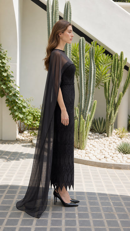 Side profile of black lace formal dress showing dramatic cape train