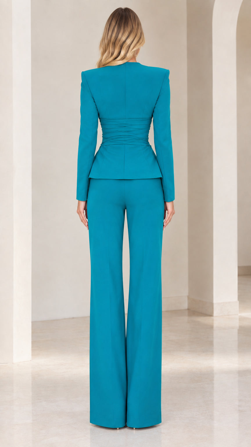 Back view of woman wearing teal long-sleeve blazer and wide-leg dress pants