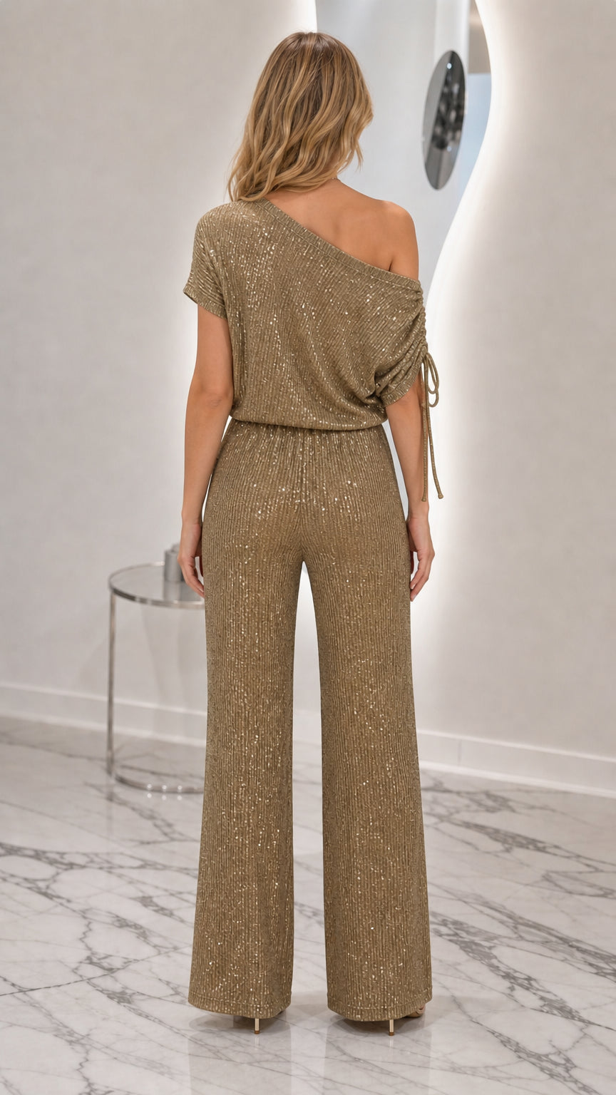 Back view of model wearing Champagne Gold one-shoulder sequin jumpsuit