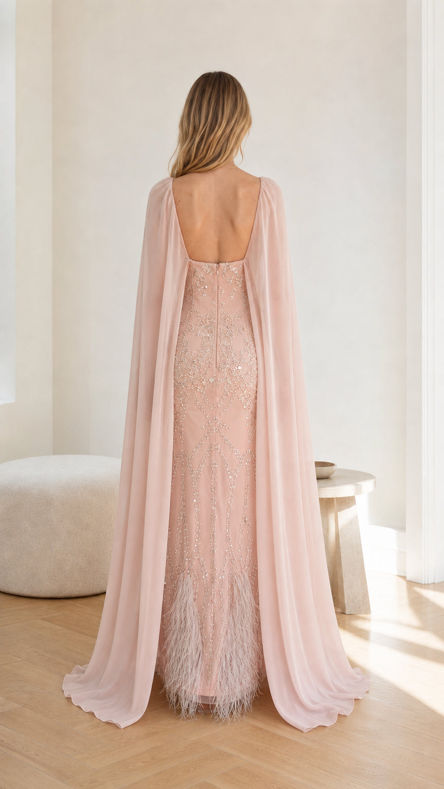 Back view of the Blush Pink evening gown showing low back and flowing cape