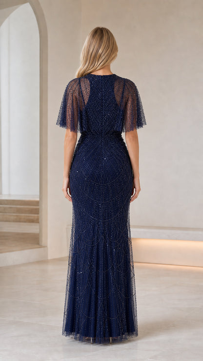 Back view of model in Navy Blue flutter sleeve beaded evening gown