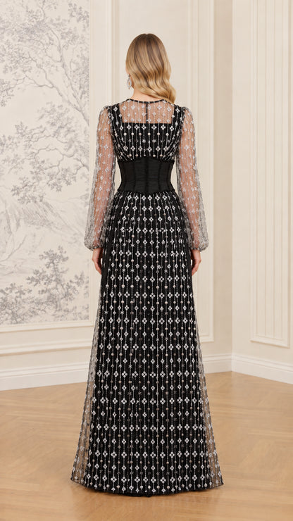 Back view of black long sleeve formal gown with sheer back yoke and full-length skirt