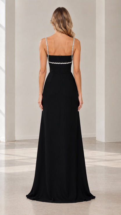 Back view of black floor-length formal dress showing straight neckline and straps