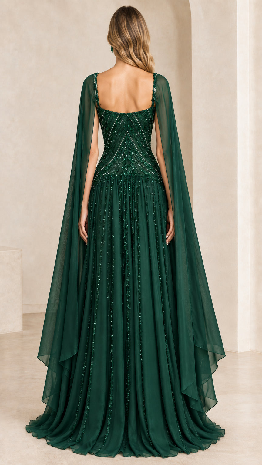 Back view of emerald green embellished floor length gown with draped back cape