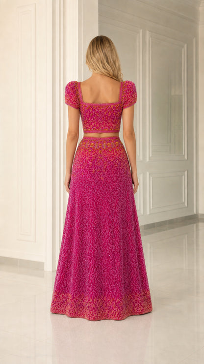 Back view of model in magenta two-piece formal gown showing fitted beaded skirt and top