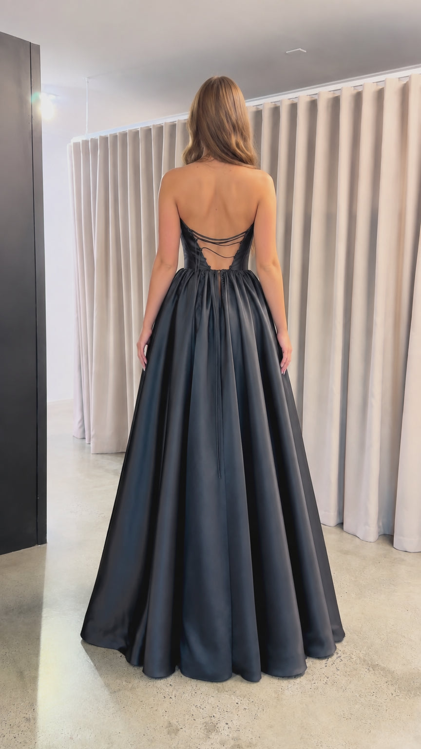 Back view of black satin evening gown showing lace-up strappy back