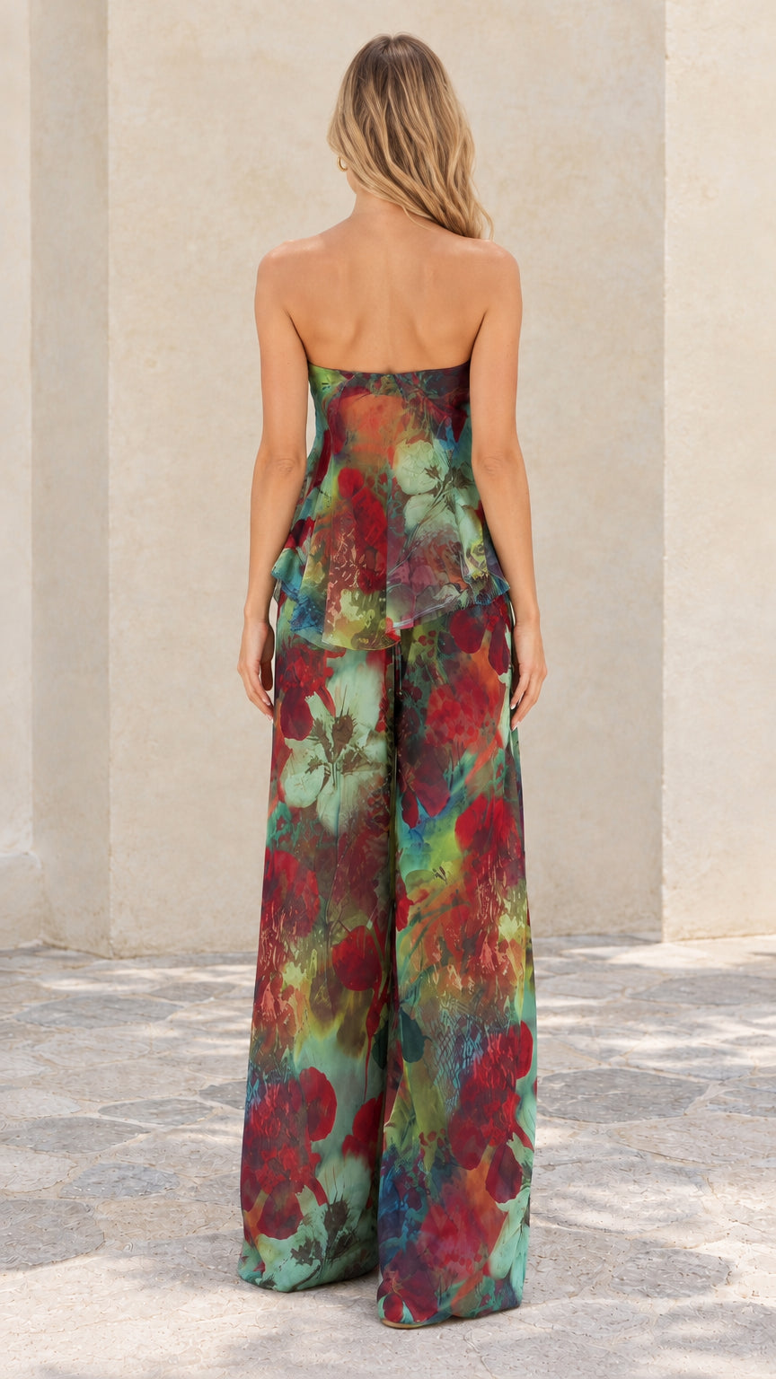 Back full view of woman in teal floral strapless top and matching wide-leg trousers