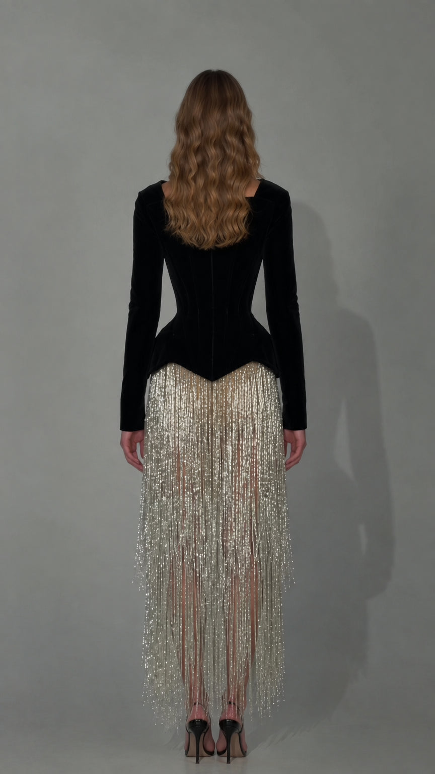 Back view of black velvet corset bodice with fitted long sleeves and fringe skirt