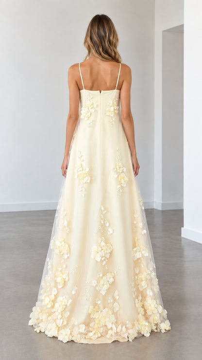 Model wearing butter yellow spaghetti strap evening gown back view