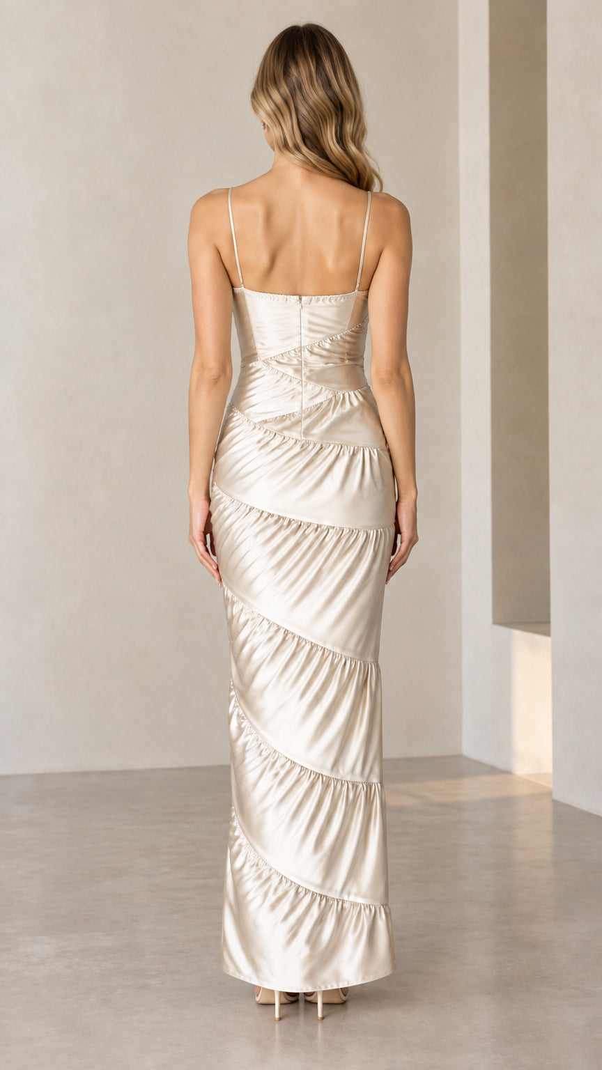 Back view of woman in Champagne spaghetti strap tiered satin gown