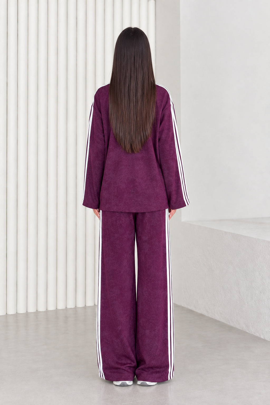 Back view of model in plum two-piece crewneck top and wide leg pants set