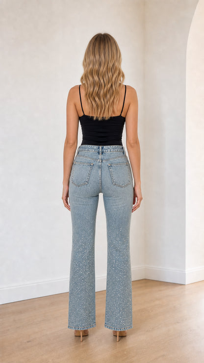 Back view of model showing high waist fit and pockets on light blue flare jeans