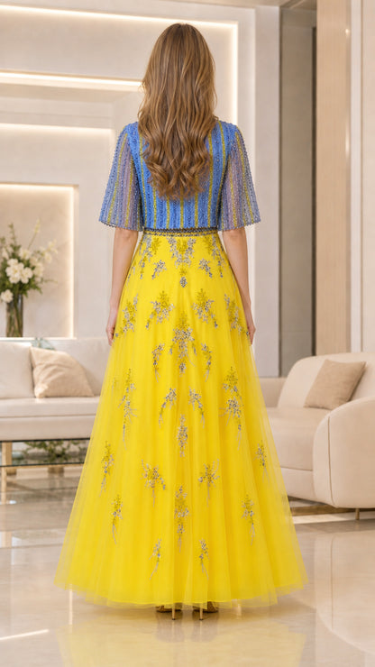 Back view of model wearing yellow and blue formal beaded tulle gown