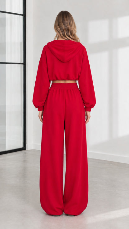 Back view of model wearing red hooded sweatshirt and relaxed sweatpants