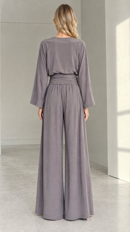 Back view of woman in a slate grey long-sleeve wide-leg jumpsuit