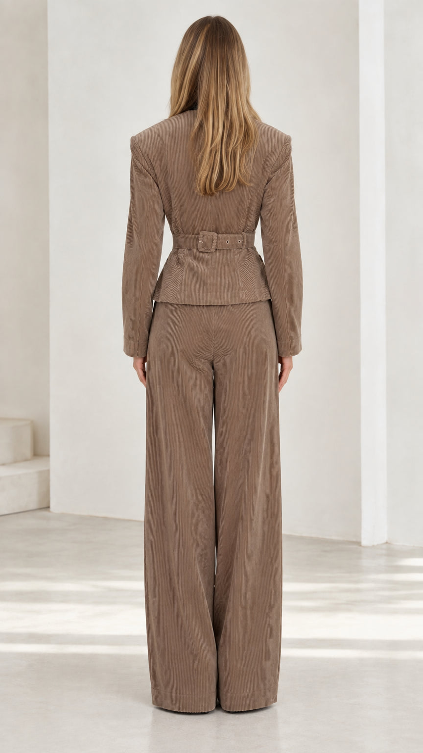 Back view of taupe corduroy suit set highlighting waist detailing and wide trouser fit