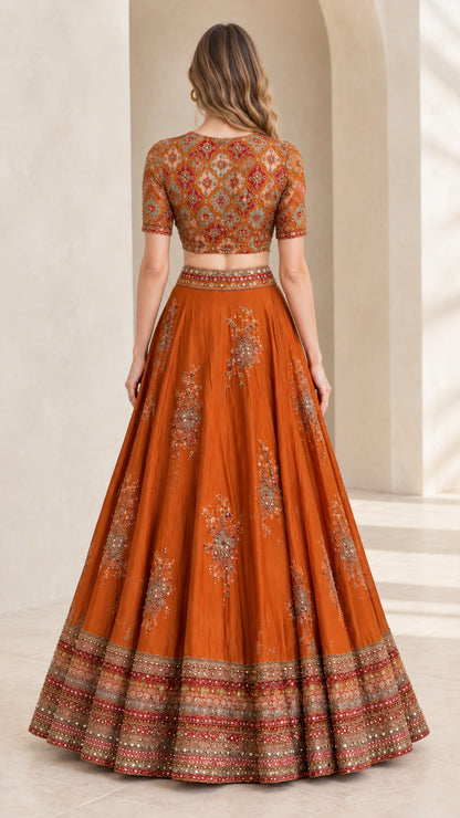 Back view of woman wearing Rust Orange embroidered crop top and pleated maxi skirt