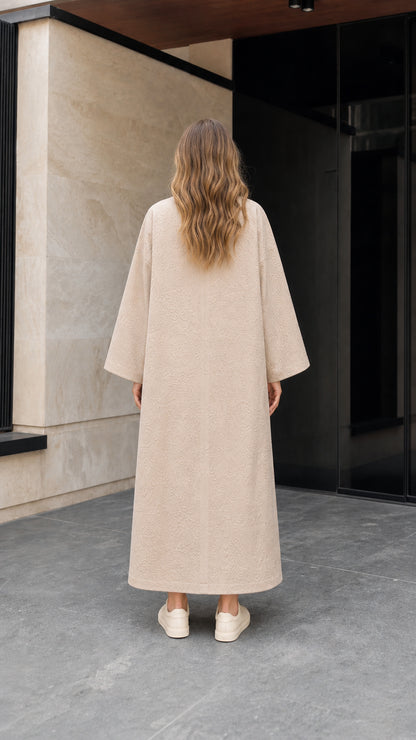 Back view of woman wearing long beige jacquard duster coat with wide sleeves