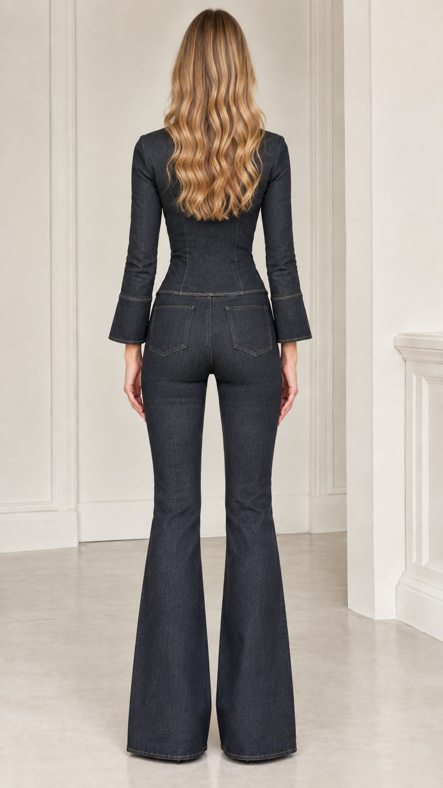 Back view of model wearing dark indigo fitted denim top and high-waisted flare pants