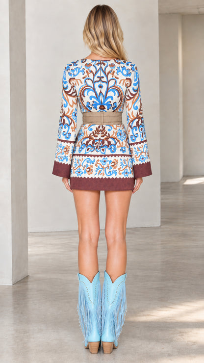 Back view of model wearing retro printed mini dress with bell sleeves