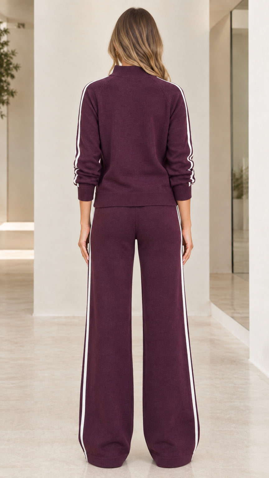 Back view of woman wearing burgundy knit two piece lounge set with side stripes