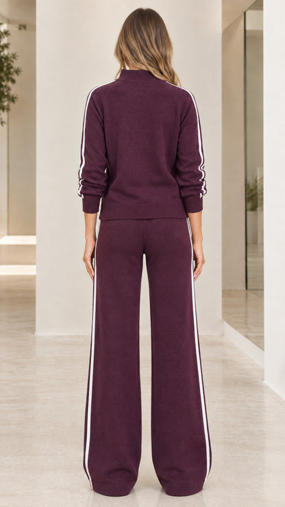 Back view of woman wearing burgundy knit two piece lounge set with side stripes