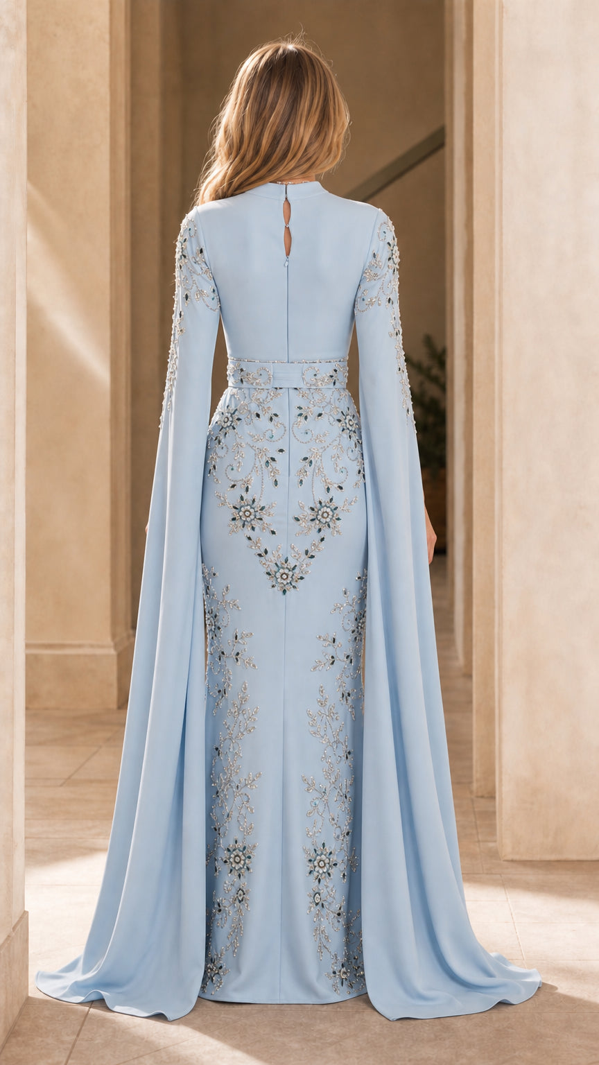 Back view of light blue floor-length gown with dramatic flowing cape sleeves
