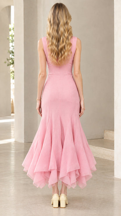 Back view of woman wearing pink sleeveless midi dress showing fitted waist and layered ruffle skirt