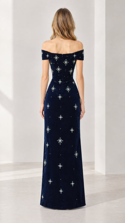 Back view of navy blue off-the-shoulder velvet maxi dress showing fitted silhouette and rear zipper