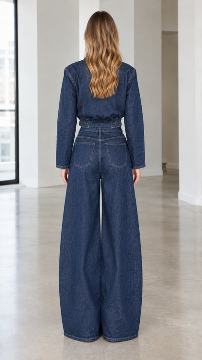 Back view of model in dark blue denim wrap jacket and high waist wide leg jeans