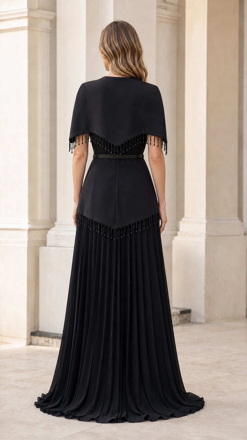 Back view of woman wearing black beaded capelet pleated formal gown