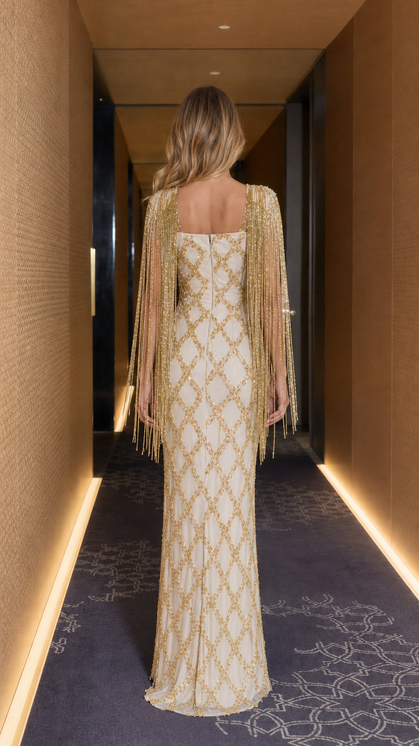 Back view of champagne beaded column gown highlighting back neckline and fringe drapes