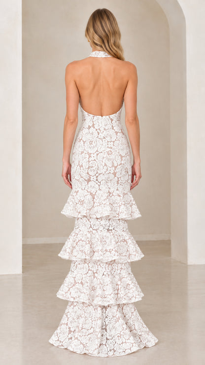 Back view of model showing open back design on White tiered lace evening gown
