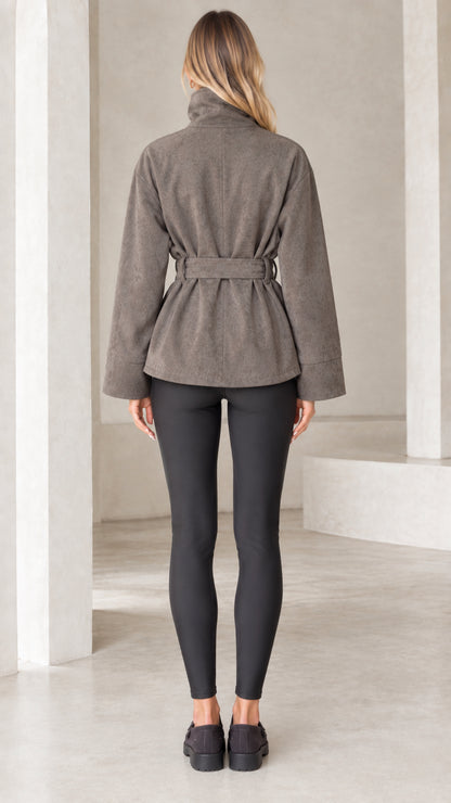 Back view of model wearing taupe belted faux suede jacket with stand collar