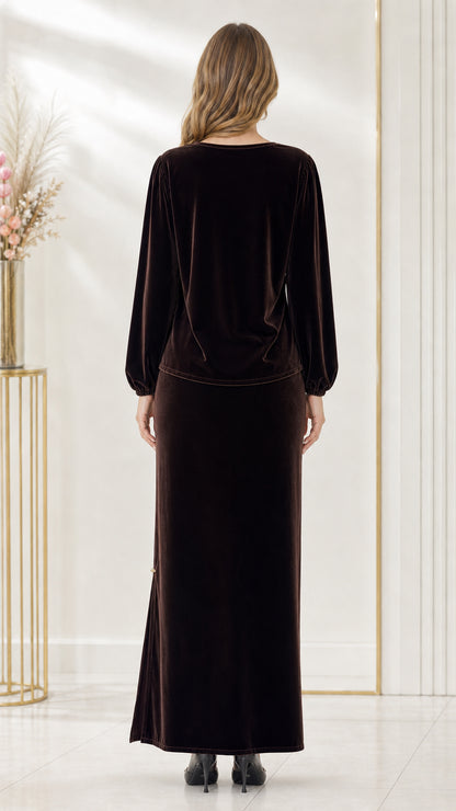 Back full-length view of woman wearing dark brown velvet long sleeve top and maxi skirt