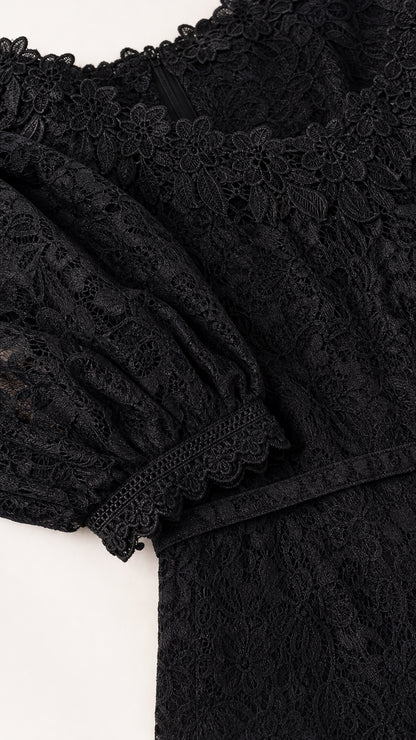 Close up of delicate black floral lace fabric and scalloped cuffs