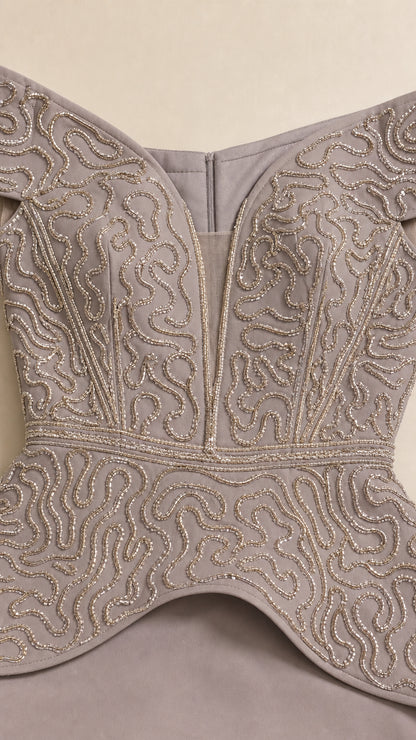 Close-up detail of swirl beaded embroidery and illusion plunge neckline on bodice