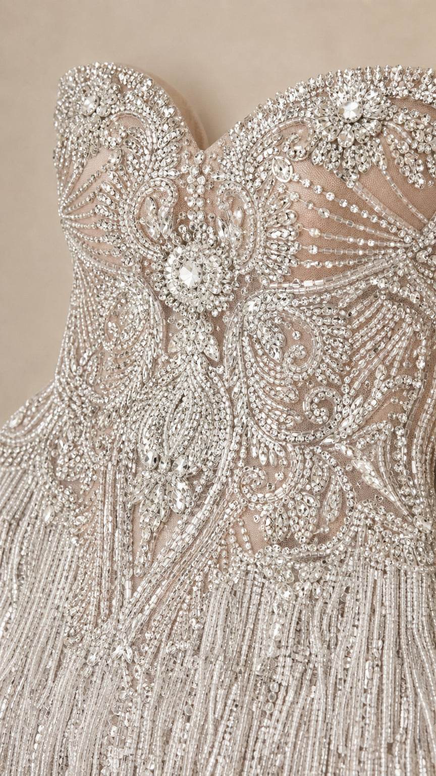 Close-up detail of ornate crystal beading and tassel fringe on bodice